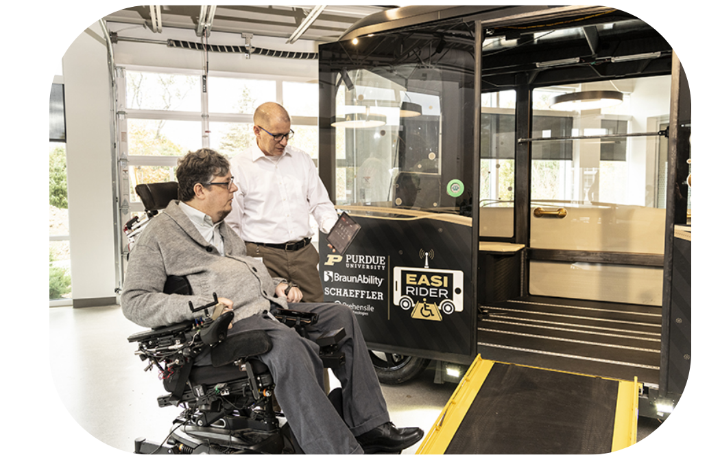 Purdue professors Phill Bell and  Brad Duerstock, a wheelchair user, looking at the autonomous vehicle, EASI Rider.
